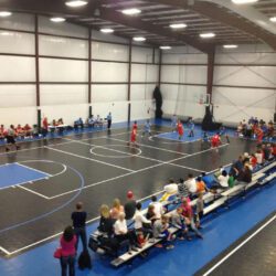 crowd watching a basketball game being played on a flexcourt court