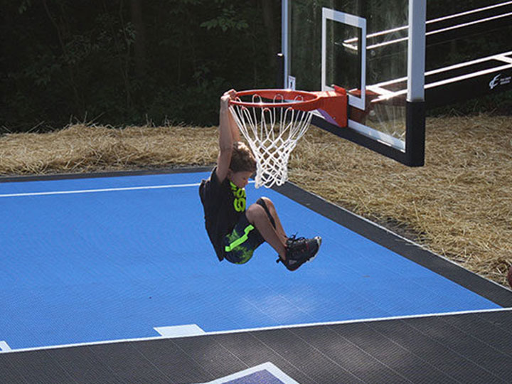 Little boy dunking a basketball on his new outdoor court
