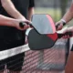 A pickleball match ends with players bumping paddles.