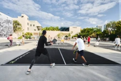 two men returning a pickleball serve from the opposing team