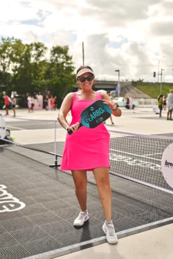 woman in a pink dress ready to play pickleball